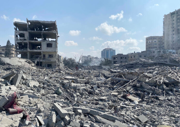 Palestinians inspect the damage following an Israeli airstrike on the El-Remal area in Gaza City